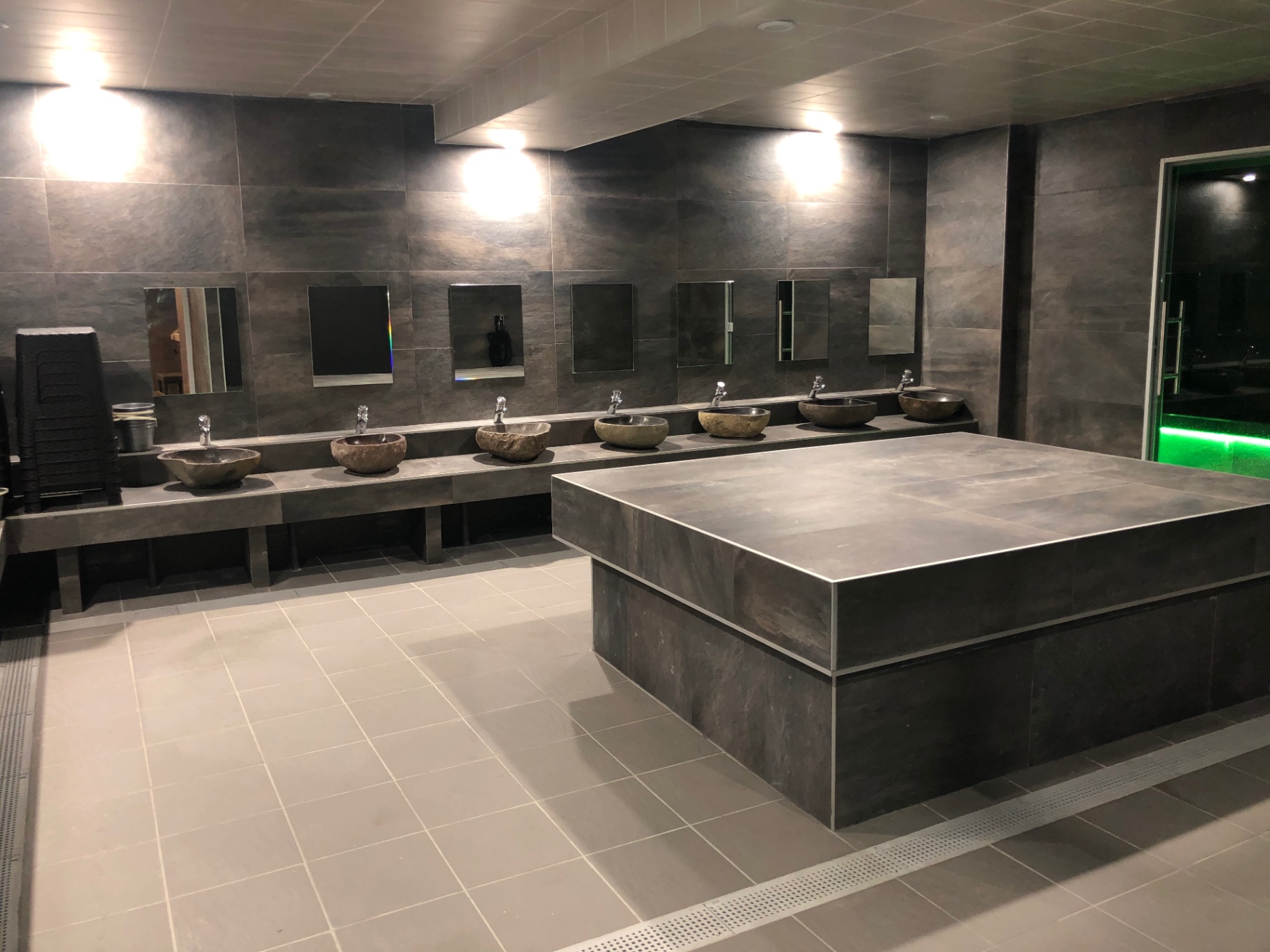Salle du hammam en pierre sombre avec sa table de gommage